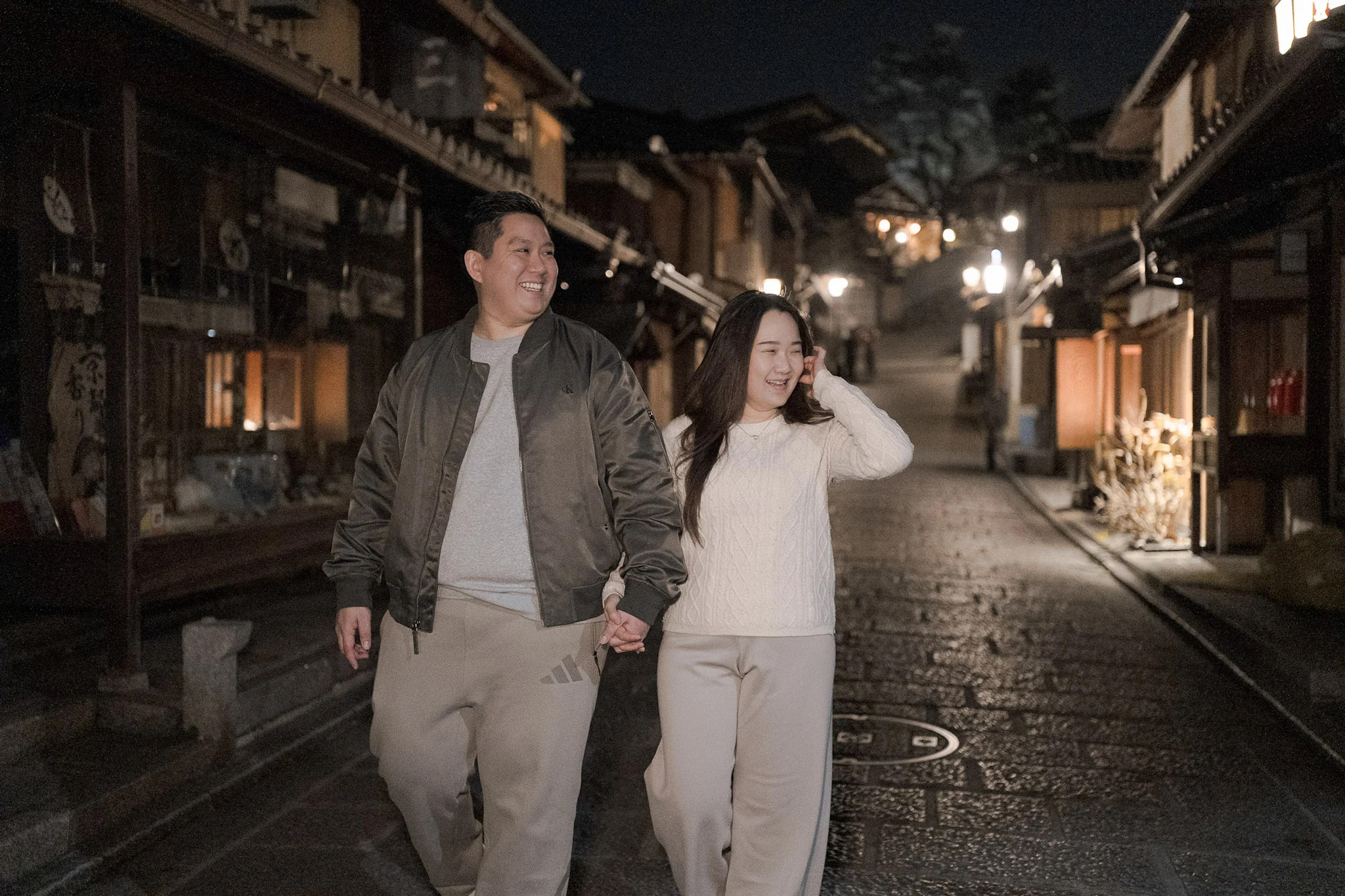 Couple walking along a softly lit Kyoto lane at night