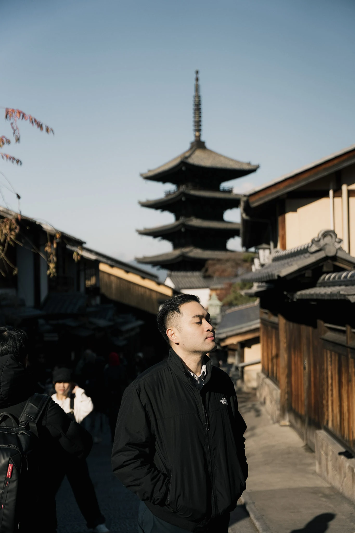 Man standing on a traditional Kyoto lane beneath Yasaka Pagoda
